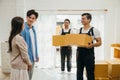 A couple receives assistance inside home from movers unloading boxes from truck Royalty Free Stock Photo