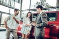 Couple receiving car keys by a dealer in a dealership Royalty Free Stock Photo