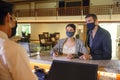 Couple and receptionist at counter in hotel wearing medical masks as precaution against virus. Couple on a business trip