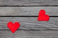 Couple of red paper hearts on gray wood, simple love story, break up