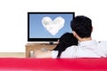 Couple on red sofa watching love cloud on tv Royalty Free Stock Photo