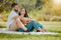 Couple relax on grass, outdoor picnic in park and love sitting on blanket in Miami garden under a tree. Romantic date in Royalty Free Stock Photo