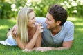 Couple, relax on grass in park with smile, love and commitment in healthy relationship. People on a date outdoor