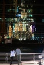 Tourists looking facade a glass wall of a modern building with reflection of building, pattern or background in Bangkok,