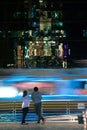 Tourists looking facade a glass wall of a modern building with reflection of building, pattern or background in Bangkok,