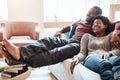 Couple, relax and watching tv on a sofa, happy and smile while bonding in their home together. Television, resting and Royalty Free Stock Photo