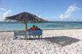 A couple relaxes under a rustic umbrella on Anegada in the British Virgin Islands Royalty Free Stock Photo