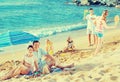 Couple relaxing on beach while their kids playing active games Royalty Free Stock Photo