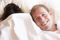 Couple Relaxing In Bed Hiding Under Bedclothes Royalty Free Stock Photo