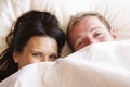 Couple Relaxing In Bed Hiding Under Bedclothes Royalty Free Stock Photo