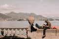 Couple relaxing on a bridge over a lake in Stresa, Italy.
