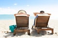 Couple relaxing on deck chairs at beach resort Royalty Free Stock Photo