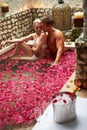 Couple Relaxing In Flower Petal Covered Pool