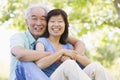 Couple relaxing outdoors in park smiling