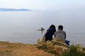 Couple relaxing on rocky bay