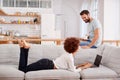 Couple Relaxing On Sofa At Home Looking At Laptop Together Royalty Free Stock Photo