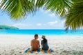 Couple relaxing under a palm tree on a white tropical beach Anse Lazio Praslin Tropical Seychelles