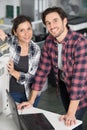 couple repairing photocopier and using laptop Royalty Free Stock Photo