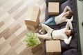 Relaxed couple resting on couch after moving in new home