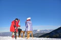 A couple is resting on lounges in picnic zone on european ski resort