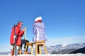 A couple is resting on lounges in picnic zone on european ski resort