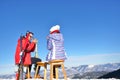 A couple is resting on lounges in picnic zone on european ski resort