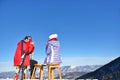 A couple is resting on lounges in picnic zone on european ski resort