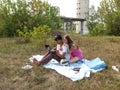 Couple resting on nature with a laptop in the fall, against a background of unfinished buildings. Young guy and girl sitting on Royalty Free Stock Photo