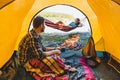 couple resting near fire. man sitting in tent woman laying on hammock Royalty Free Stock Photo