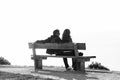 A couple rests on a wooden bench