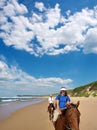 Couple of riders on beach under dramatic skies Royalty Free Stock Photo