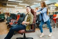 Couple rides on office chair in furniture store Royalty Free Stock Photo