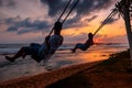 Couple rides on swings on sunset Royalty Free Stock Photo