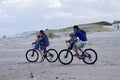 Couple riding a bicycle with their children on the beach of Ibiraquera, Santa Catarina Brazil - March 13, 2016.
