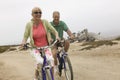 Couple Riding Bicycles On Beach