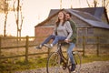 Couple Riding Bike Through Countryside With Woman Sitting On Handlebars