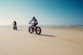 couple riding fat bike on beautiful sunny beach Royalty Free Stock Photo