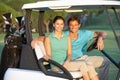 Couple Riding In Golf Buggy Royalty Free Stock Photo