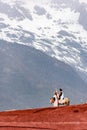 Couple pointing at snow mountain, China