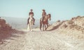 Couple riding horses in countryside nature tour - Happy people having fun on summer day - Vacation, excursion, healthy lifestyle,