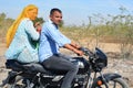 Couple riding on scooter through busy highway street