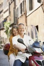 Couple Riding Scooter On Street