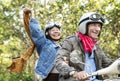 Couple riding scooter together in forest Royalty Free Stock Photo