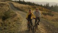 Couple riding sport bikes in landscape. Active woman and man cycling on road
