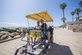 Couple riding a surrey bike ride along the coast of California Royalty Free Stock Photo