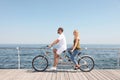 Couple riding tandem bike near sea