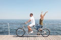 Couple riding tandem bike near sea