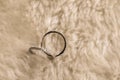 Couple rings placed on a soft white wool. Sepia tone.