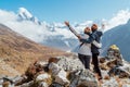 Couple rising arms rejoicing Everest Base Camp trekking route near Dughla 4620m. Backpackers left Backpacks and trekking poles and Royalty Free Stock Photo