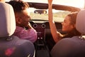 Couple On Road Trip Driving In Convertible Car